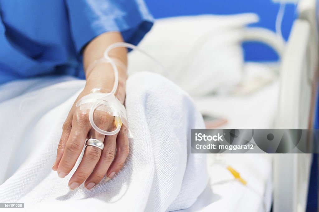 iv drip in woman hand close up of iv drip in woman hand on bed in hospital Adult Stock Photo