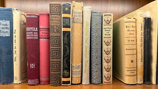 image of open antique book on wooden table with glitter background