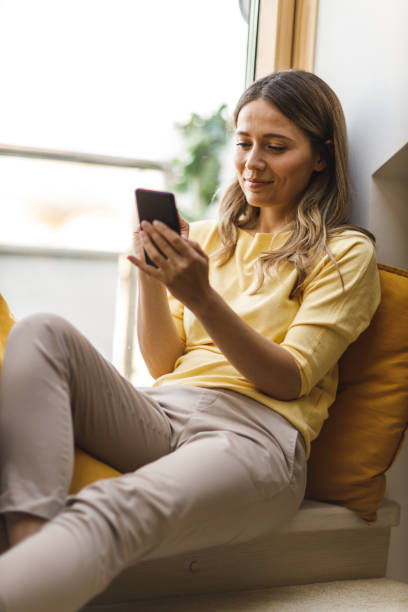 istock Woman relaxing on the window sill 1641958810