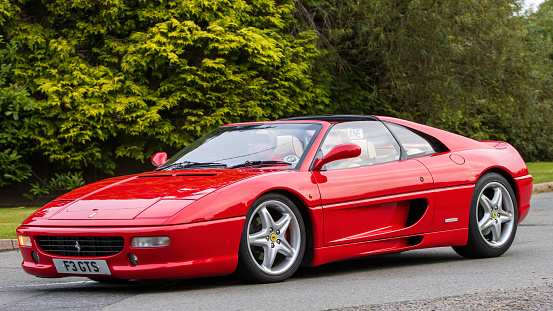 Whittlebury,Northants,UK -Aug 26th 2023: 1999 red Ferrari 355 car travelling on an English country road
