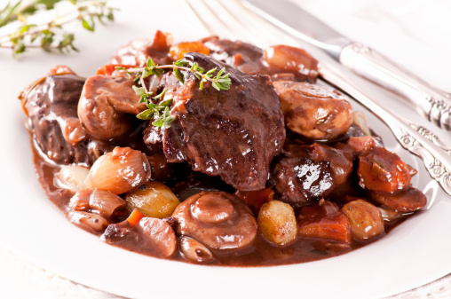 Boeuf bourguignon with vegetable as closeup on a white plate.