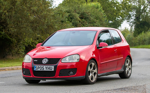 Whittlebury,Northants,UK -Aug 26th 2023: 2005 red Volkswagen Golf GTI car travelling on an English country road
