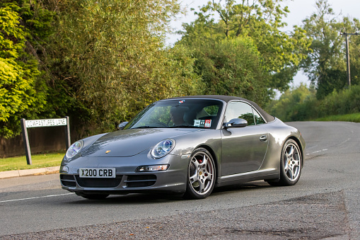 Whittlebury,Northants,UK -Aug 26th 2023: 2009 grey Porsche 911 Carrera car travelling on an English country road