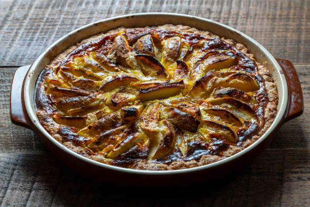 istock Apple pie in a ceramic baking dish on a wooden table. Homemade apple pie. Closeup 1641970751