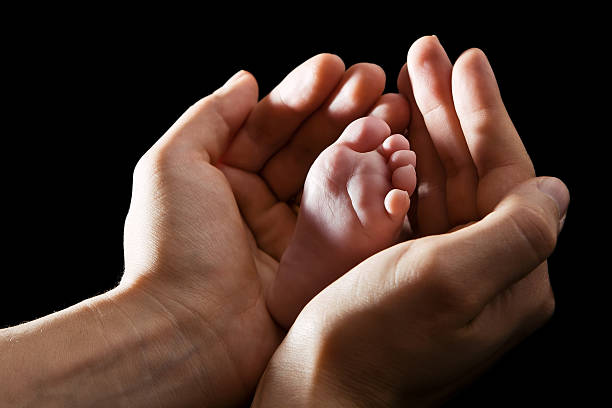 mains tenant bébé pied - multi generation family adoption family human hand photos et images de collection