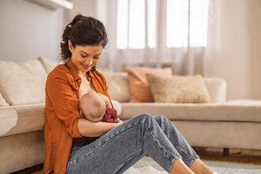 Portrait of mom and breastfeeding baby.Young mom breastfeeding her baby at home.