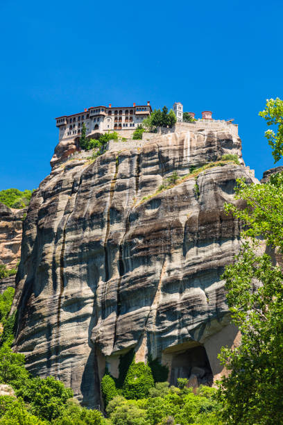 the monastery of varlaam on a rocky mountain on the cliffs of meteora, greece - greece blue forest national landmark imagens e fotografias de stock