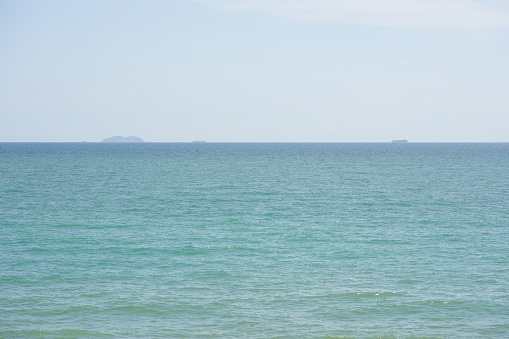The sea is beautiful, the sky is clear, you can see the island in the distance.