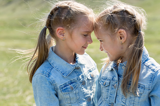 Little girls twins hug each other. Wonderful emotions girls