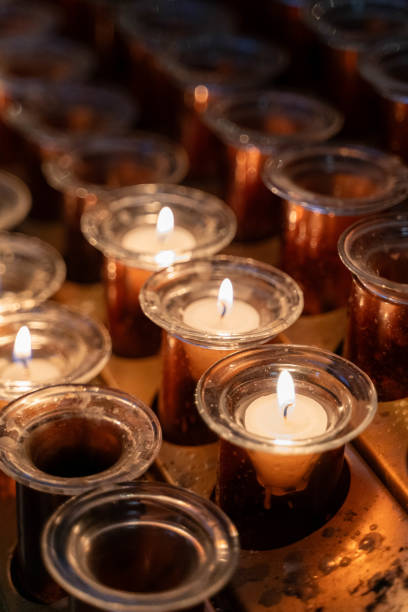 atear fogo a uma vela de cera na igreja - hanukkah menorah human hand lighting equipment - fotografias e filmes do acervo