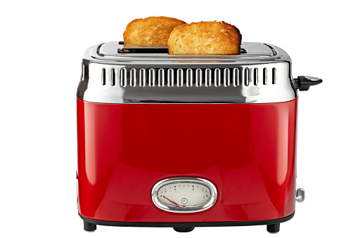 Modern red toaster with toasted bread for breakfast inside, isolated on white background. File contains clipping path. Full depth of field.