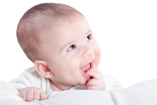 Caucasian Four months old Baby boy smiling with fingers in Mouth