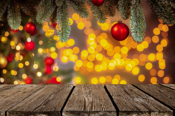 istock Empty wooden table with defocused Christmas lights and baubles background 1642116346