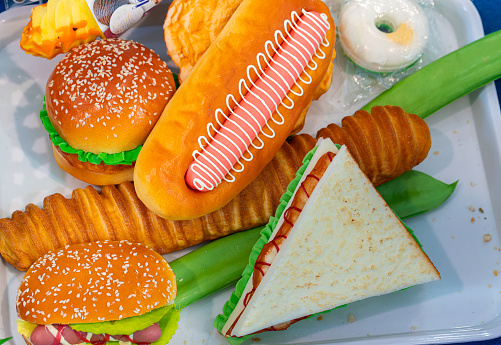 Various fast food on a plate: hot dog, burger, sandwich