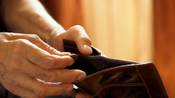 istock An elderly man's hands, covered with knotted veins, search for coins in his wallet 1642185704