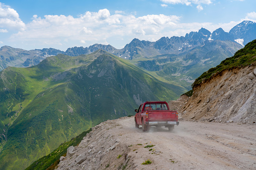 A red pickup truck driving on dirt roads on high plateau roads in Turkey