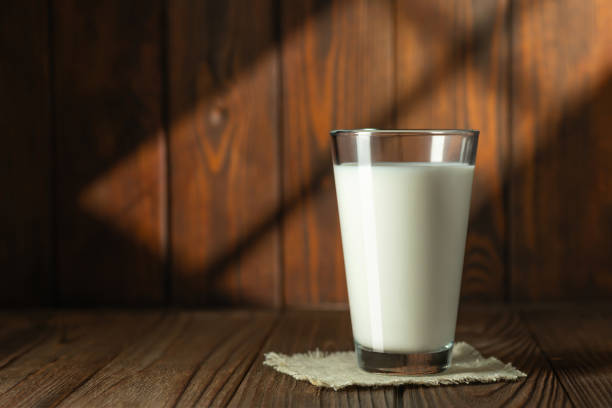 istock milk in glass on wooden table with sun rays 1642223114