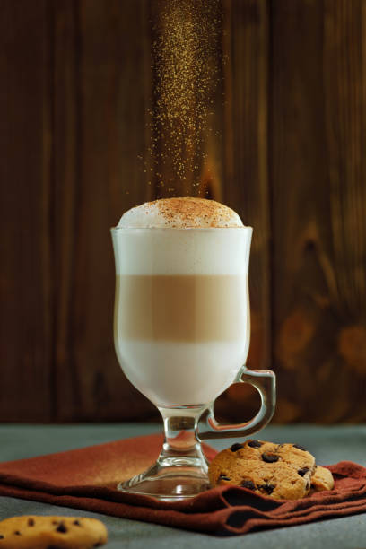 istock latte macchiato in glass cup with falling cinnamon powder 1642223115