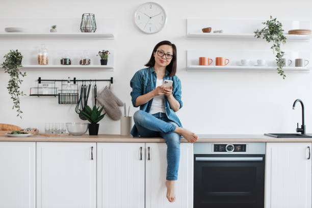 istock Young homebody resting with mobile on countertop in kitchen 1642272719