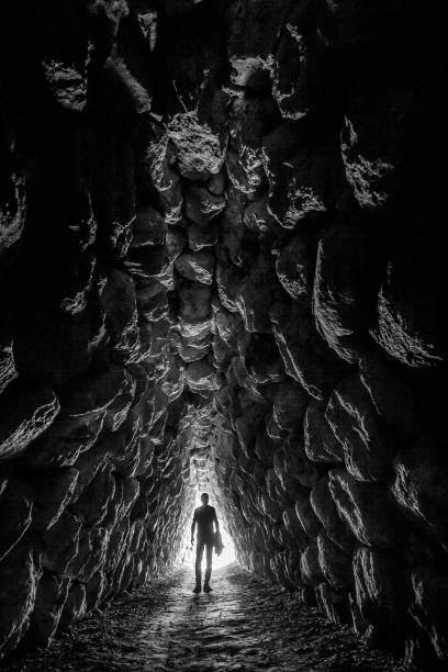 istock A man walking in a tunnel made of stones 1642282909
