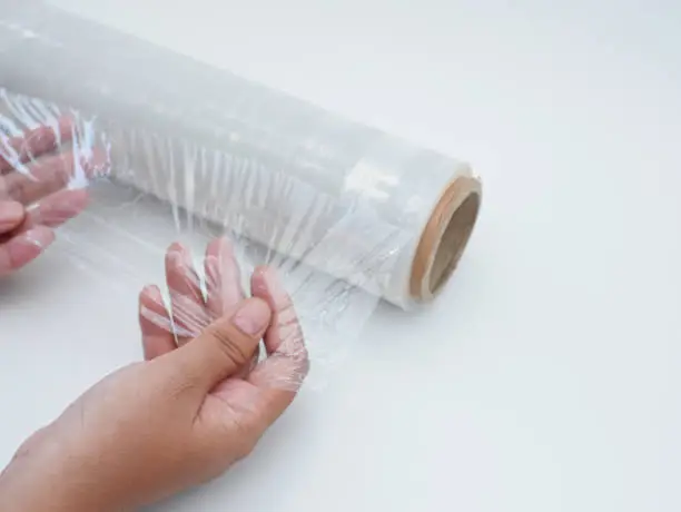 Roll of transparent plastic wrapping on white background