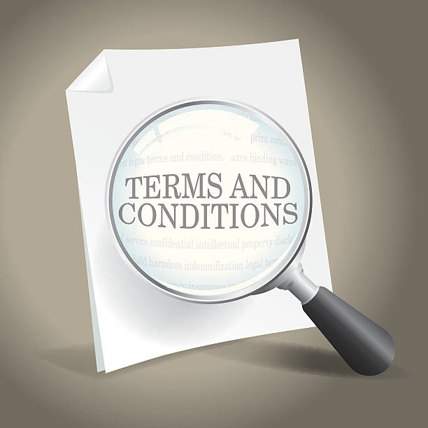 A photo of the terms and conditions with a magnifying glass Examining the Terms and Conditions of a Legal Agreement. read the fine print stock illustrations