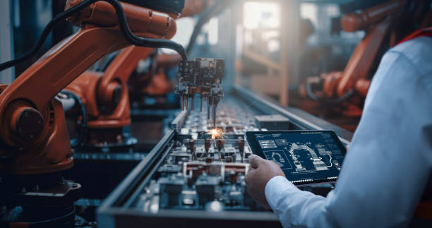 Engineers test the control of robot arm, Intelligent machine in factory industrial on real-time monitoring system software. Robots weld workpieces and produce industrial parts to reduce human labor. los ingenieros prueban el control del brazo robótico, la máquina inteligente en la fábrica industrial en el software del sistema de monitoreo en tiempo real. los robots sueldan piezas de trabajo y producen piezas industriales para reducir el trabajo hum
