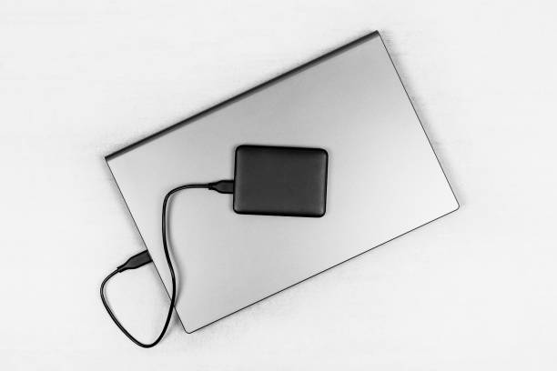 istock laptop and hard drive on a gray background top view 1642377856