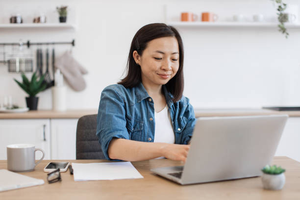istock Female adult using portable device in kitchen interior 1642378685