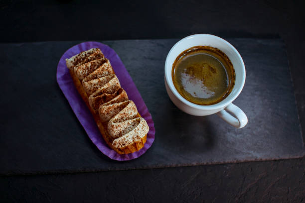 istock Cup of coffee and delicious eclair cake 1642388863