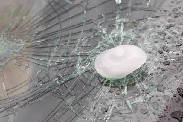 Close-up of damaged car windshield by hail