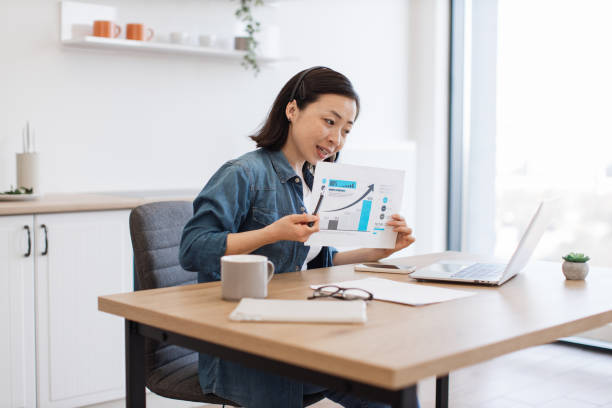 istock Woman analyzing graph on video conference via laptop at home 1642397451