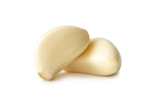 Two fresh peeled garlic cloves are isolated on white background with clipping path.
