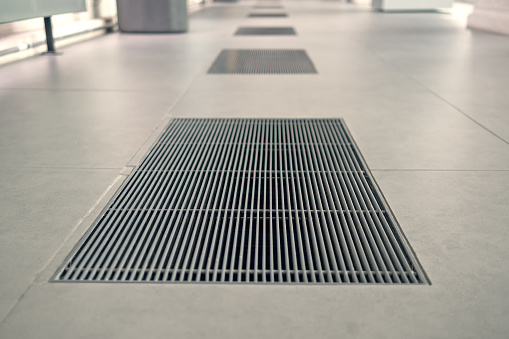 A series of gratings in the granite floor for water drainage