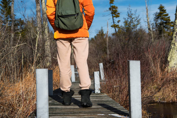 istock woman walking on a boardwalk in nature 1642436333