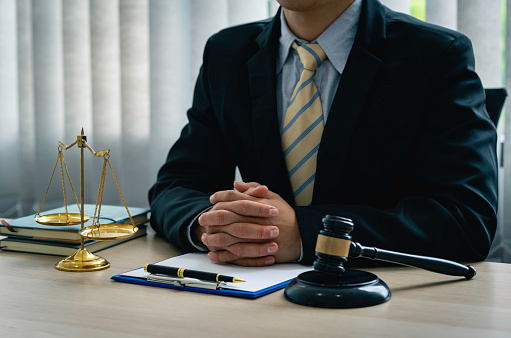 A lawyer or judge is listening to a legal testimony from a client in the lawyer's office. legal advisor Scales of Justice, Law Hammer, Litigation and Justice