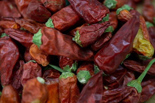 Closeup of a vibrant pile of dried red chili peppers, perfect for adding a kick of flavor to any recipe