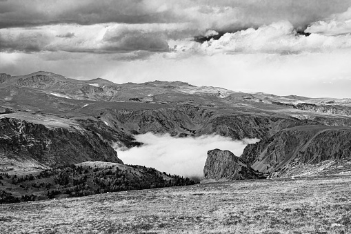 Fog in the deep valley of the Beartooth Mountain Range Wyoming in black and white