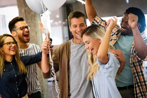 Photo of Happy multiracial group of business people having fun while celebrating on surprise party in office.