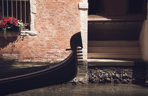 Close up with a traditional gondola boat ride on the water canal in Venice, Italy.