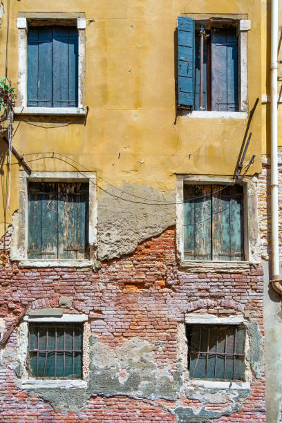 Old medieval worn out brick wall building in Venice, Italy.