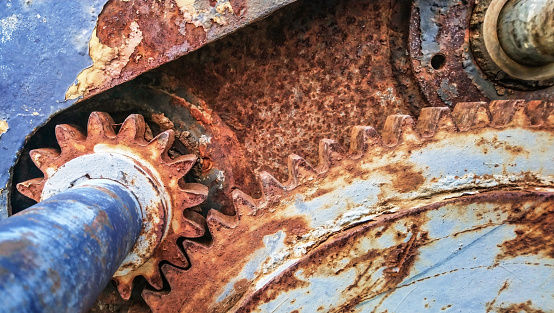 High resolution Image of an old, scrapped, rusty, heavy duty, manual marine winch gear wheel transmission mechanism detail.
