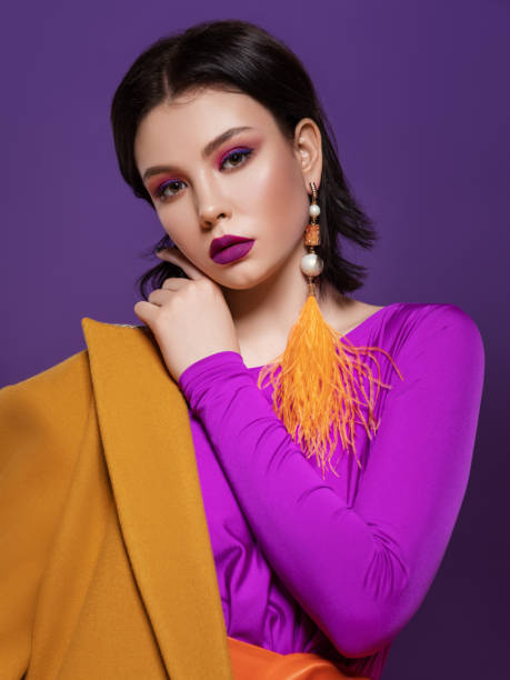 istock Fashion model on yellow and purple studio background 1642515200