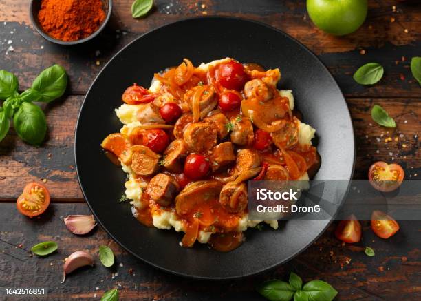 Devilled Sausages With Mashed Potato Spiced Tomato And Apple Sauce Stock Photo - Download Image Now