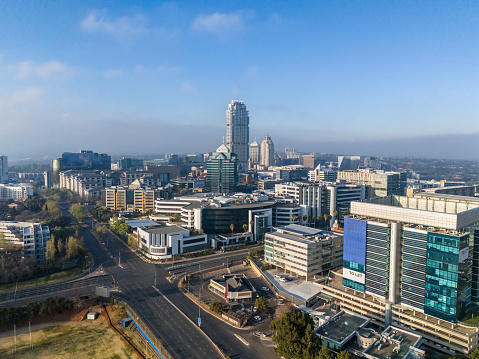 Sandton city in the morning seen with Rivonia Rd and Grayston Dr intersection and the skyscapers Michelangelo hotel and Leonardo building being the tallest.