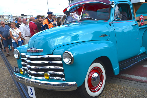 Blankenberge, West-Flanders, Belgium - August, 27, 2023: beautiful blue turquoise collector item, Chevrolet 3001 oldtimer riding in the streets in Belgium on a sunny summer day