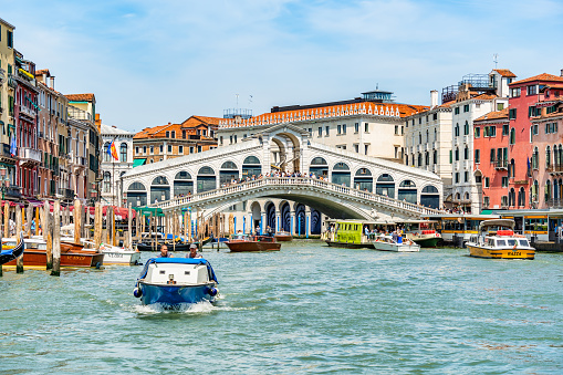 Venice, Italy - May 30 2023: Intense water traffic on Grand Canal near Rialto Bridge in Venice.