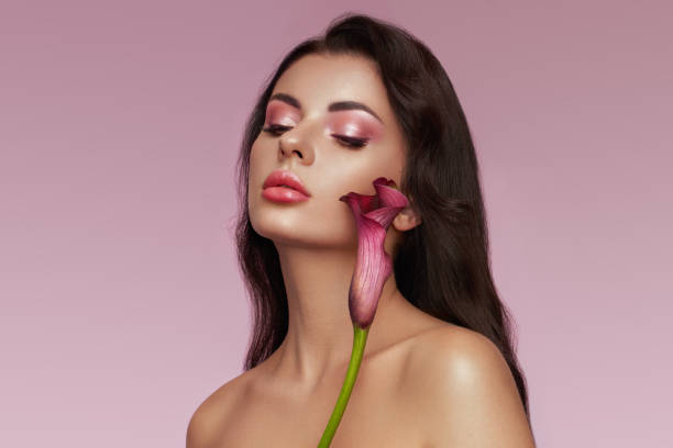 istock Beautiful young woman with a calla flower 1642532895