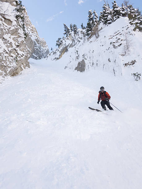 Off-piste skier in a steep chute stock photo