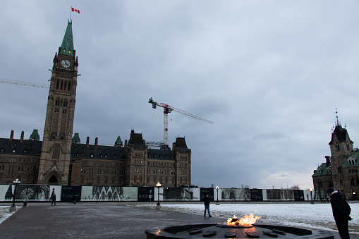 Seen from Centennial Flame on a cloudy, snowy afternoon in Ottawa, the Parliament of Canada building.